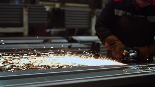 Ein Industriearbeiter ist in einer Fabrikwerkstatt mit dem Schweißen von Metall beschäftigt