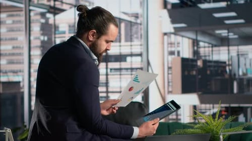 Man in Suit Analyzes Data in Modern Office