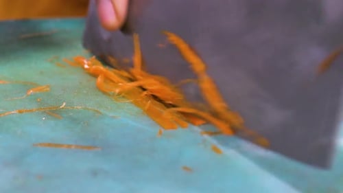 Close-Up of Carrot Chopping with Knife on Cutting Board
