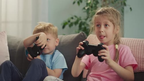 Konzentrierte Kinder treten gegeneinander an und spielen lustige Videospiele mit Konsolen