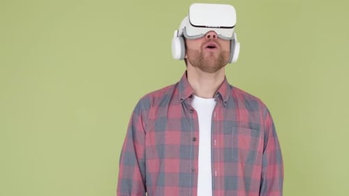 Bearded Man Wearing Virtual Reality Glasses in Studio Using a Smartphone with a VR Headset