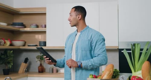 Handsome Man Using Tablet in Bright Kitchen