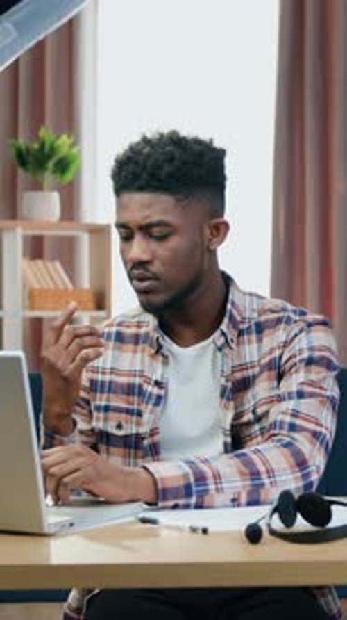 Young Man Works at Laptop Inside Home