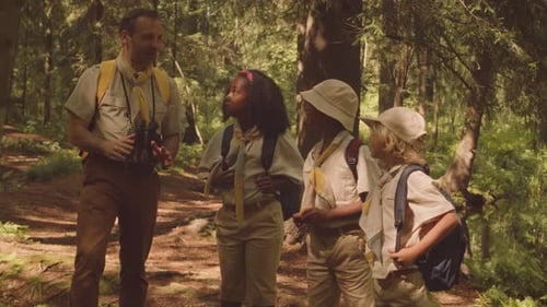 Scouter with Multiethnic Kids Exploring Forest