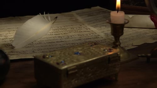 Escritorio con partituras vintage y diapasón, iluminado a la luz de las velas