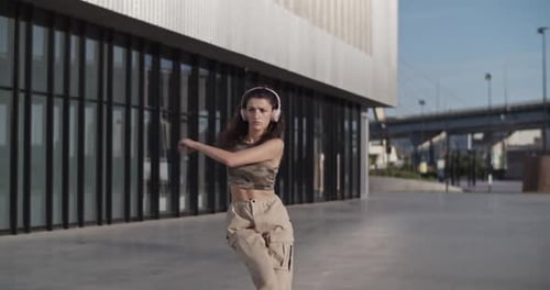 Energetic Woman Dancing Outside Contemporary Building