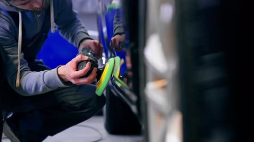 Closeup of the Hands of a Car Mechanic at a Service Station Doing the Final Polishing to Shine
