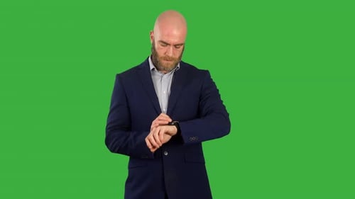 A businessman looking at a message notification on his smart watch on green screen