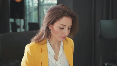 Businesswoman in Yellow Blazer Looking at Camera
