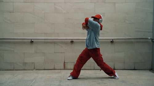 Handsome choreographer practice street dance in gray background. Sprightly.