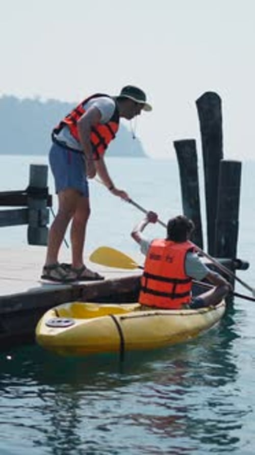 Kayak Instructor Helping a Beginner Prepare to Paddle on the Harbor Dock