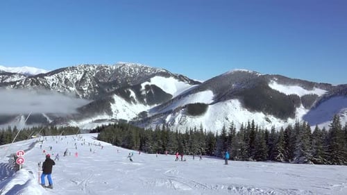 Mountain Peaks and Skiers on the Ski Slope