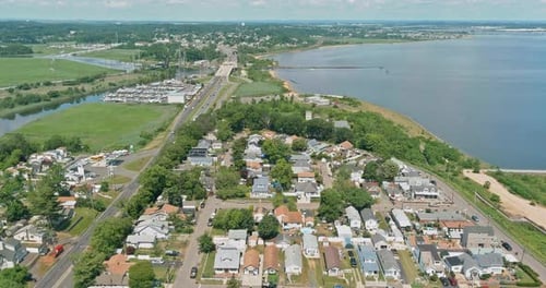 Aerial View of a Coastal Town Showcasing Homes Roads and Waterfront Activities