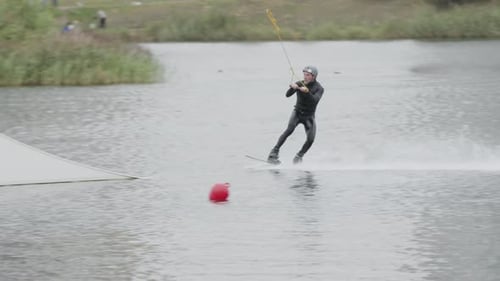 Adult Surfer Practicing Tricks on Wakeboard in Cable Park