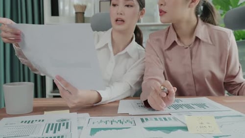 Deux jeunes femmes d'affaires enthousiastes travaillent ensemble dans l'espace de travail du bureau.