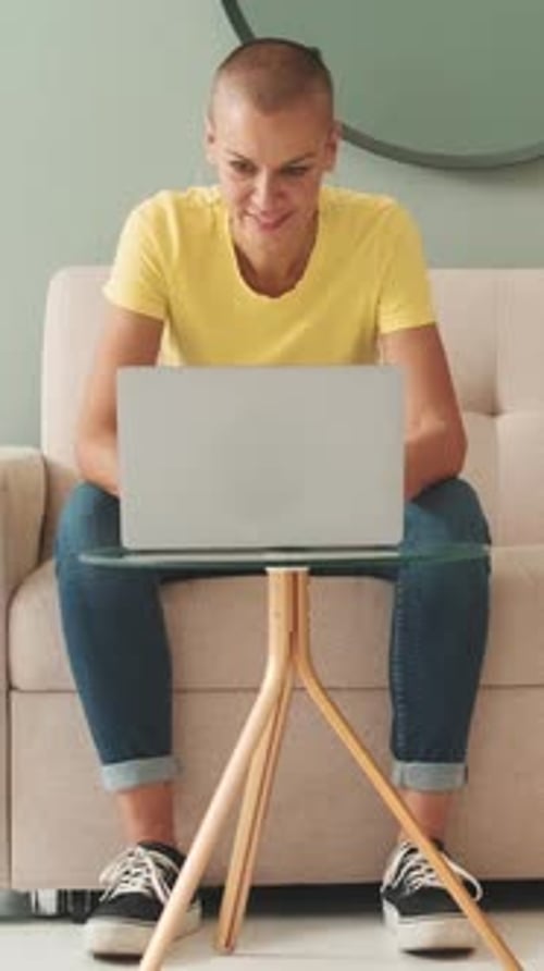 Woman Using Laptop While Sitting on Couch