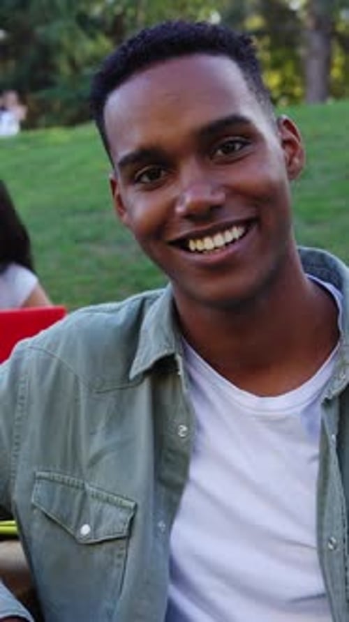 Young Man Smiling Outdoors in Natural Light