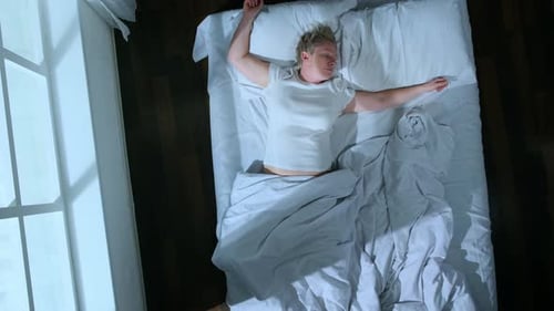 Top view of sleeping woman moves in dream changing positions in bed in room