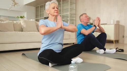 Senior Couple Meditating Together in Their Living Room