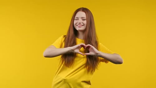 Woman Makes Heart Shape with Hands