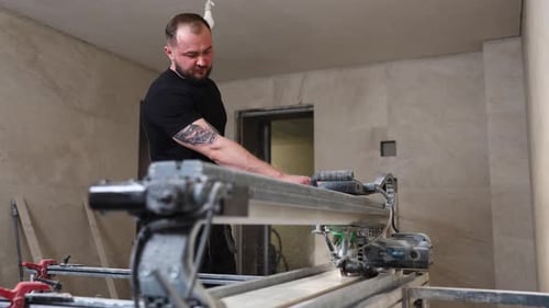 Man Cutting Tile with Wet Saw Indoors