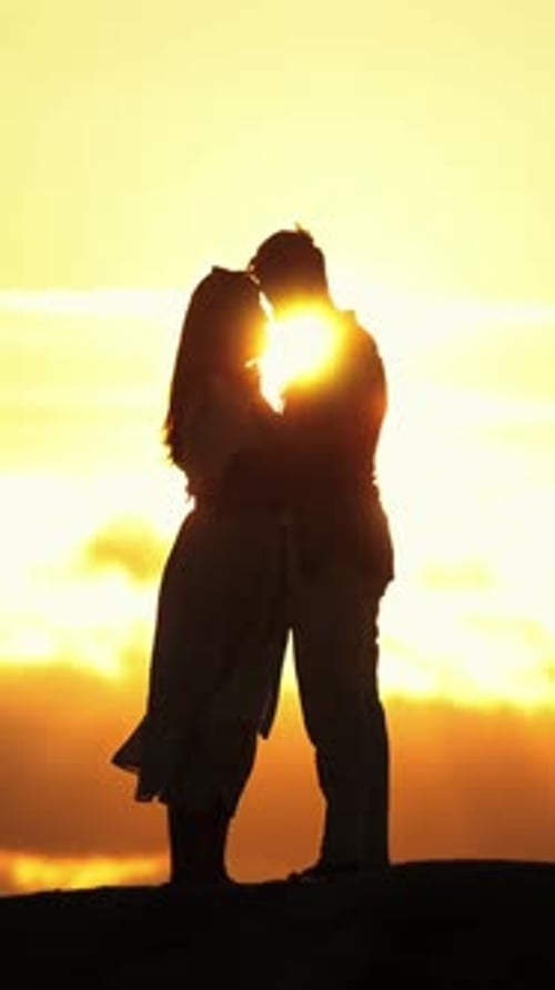 Silhouetted Couple Embrace during Sunset