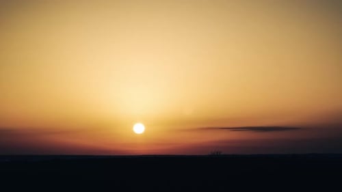 Zeitraffer des Sonnenuntergangs am orangefarbenen Himmel über dem Horizont