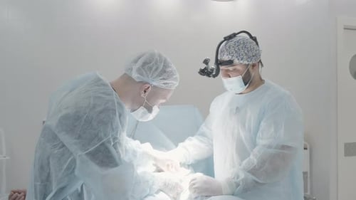 Side view of male surgeons in the operating room of a hospital