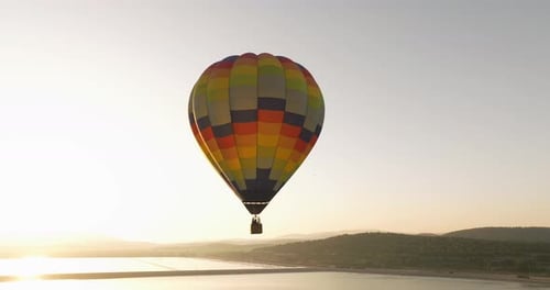 Hot Air Balloon Floating over Lake at Sunset
