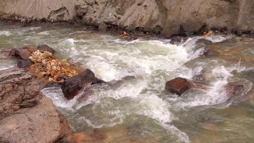 Close fixed view of a clear water river in Landmannalaugar, Iceland, descending from Brennisteinsald