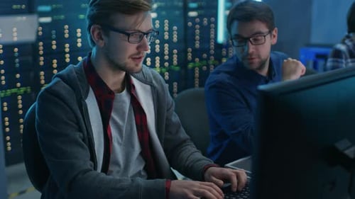 Team of Young IT Programers Working on Desktop Computers in Data Center System Control Room. Displa