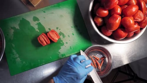Overhead View of Chef Cutting Tomatoes on Board