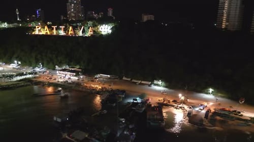 Drone Fly panoramic at Pattaya Thailand night, city logo, waterfront street and beach, famous hot to