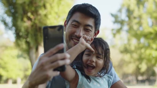 Father and Child Smiling and Posing for Selfie