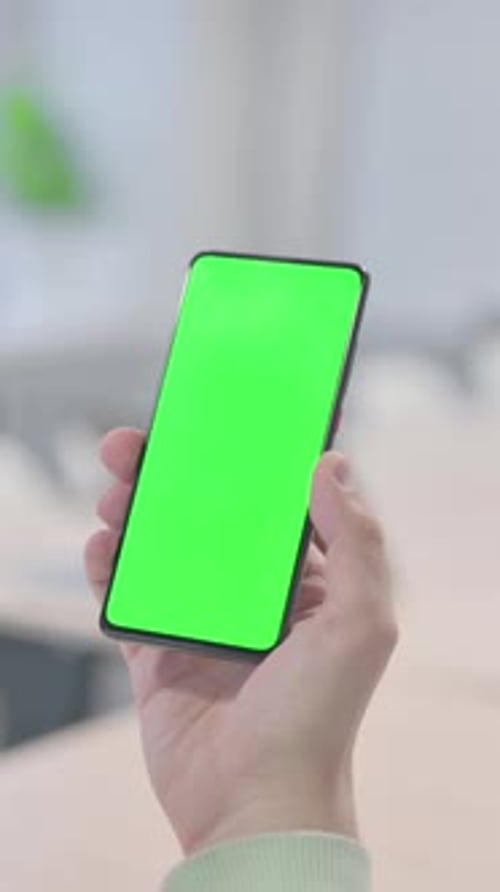 Young Man Using Smartphone with Chroma Key, vertical video