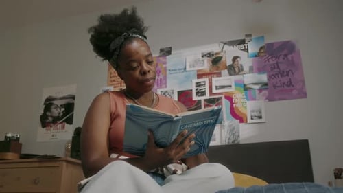 Young Adult Reads Chemistry Textbook in Bedroom