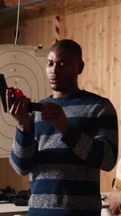 Man Demonstrating How To Load Ammunition Into Pistol