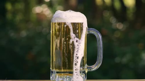 Refreshing Beer Mug with Overflowing Foam Outdoors