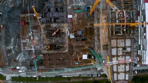 Aerial Top Down View of Construction Site with Tower Cranes Working and Building New Skyscraper