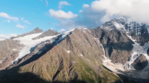 Aerial View of a Stunning Mountain with Overhanging Glaciers on a Sunny Day