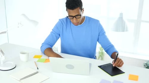 Young Adult Working with Graphic Tablet and Laptop