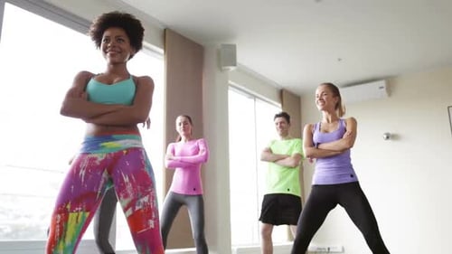 Group of Smiling People with Coach Dancing Zumba in Gym or Studio Active