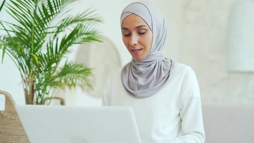 Woman with Headscarf Using Laptop at Home