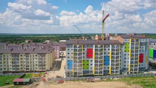 New high rise building with colorful exterior. Construction site with modern apartments in the city.
