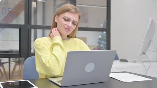 Young Woman Experiences Neck Pain at Desk