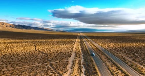 Amazing view of the desert crossed by the highways. Some cars move by the roads.