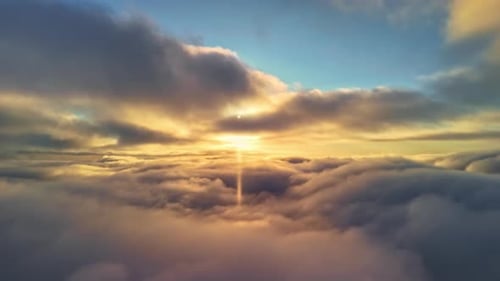 Goldener Sonnenuntergang durchbricht die Wolken und wirft warmes Licht über den Himmel mit leuchtenden Orangetönen