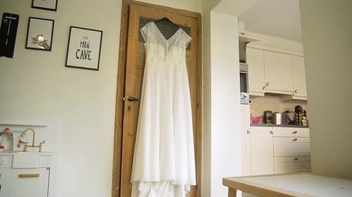 Elegant Wedding Dress Hanging in Bright Room