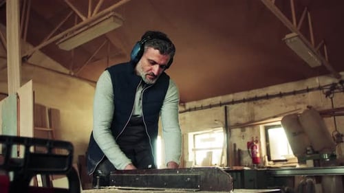 A Man Worker in the Carpentry Workshop, Working with Wood