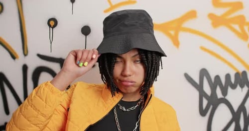 Stylish young woman in front of graffiti wall